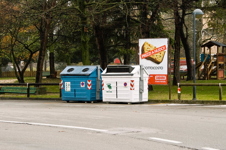 An ad, placed near a dust bin, promotes the discount on the price of food and goods of a supermarket.