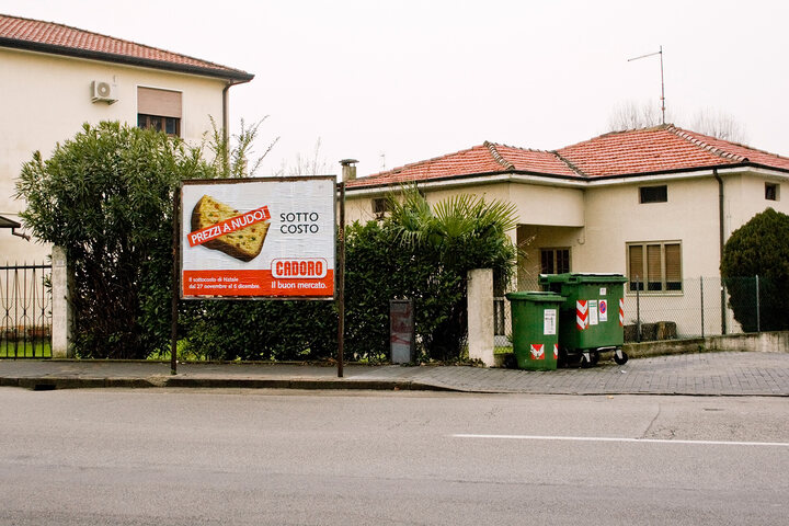 
      An ad, placed near a dust bin, promotes the discount on the price of food and goods of a supermarket.
      